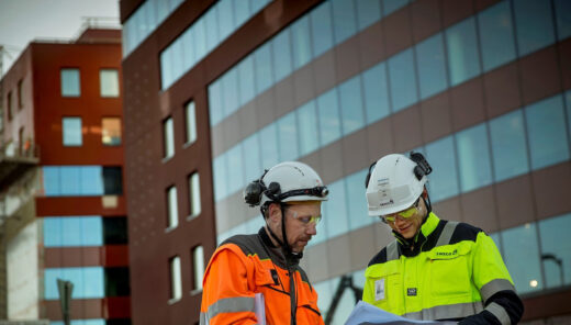 Två personer står utanför ett hus.