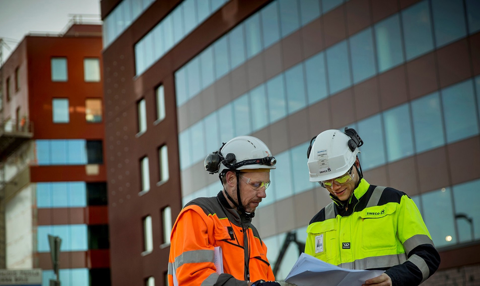 Två personer står utanför ett hus.