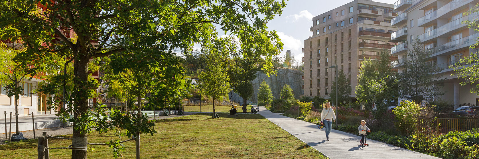 Mamma och barn på promenad i grönområde