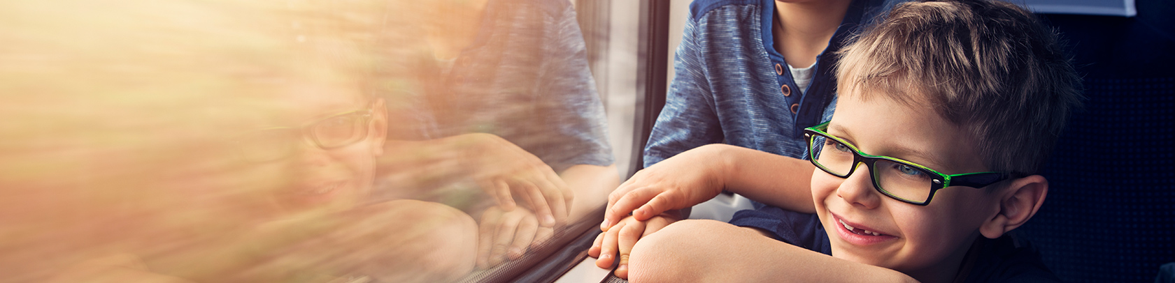 Två pojkar tittar ut genom tågfönster