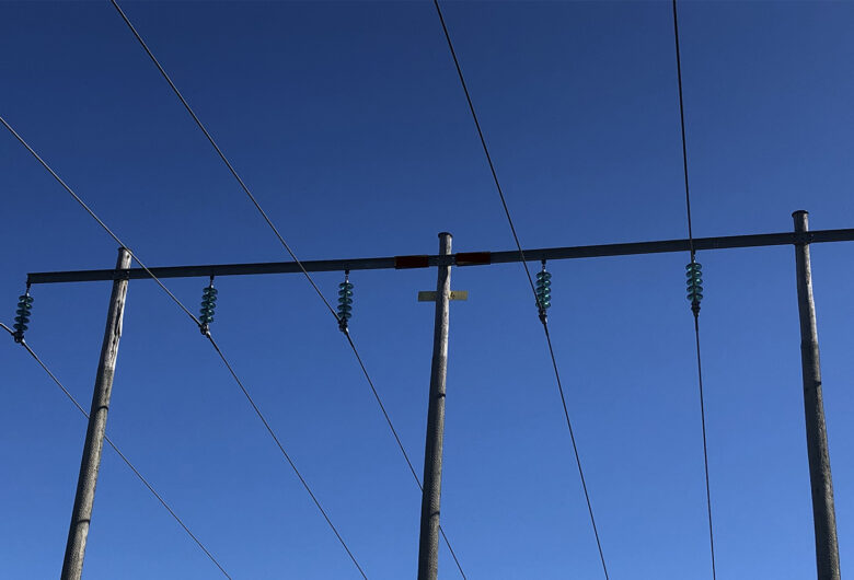 Kraftledningar mot en blå himmel