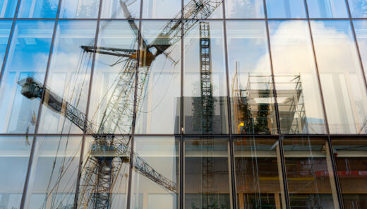 Ett bygge speglas på en fasad