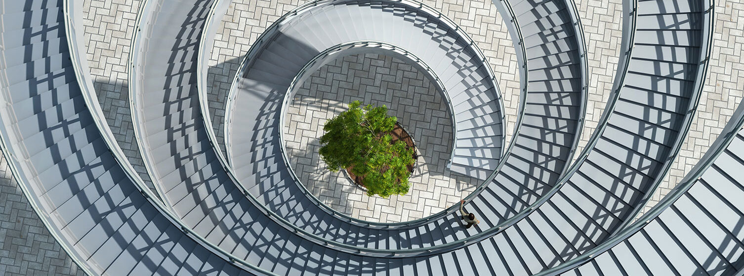 Spiraltrappa med ett grönt träd i mitten