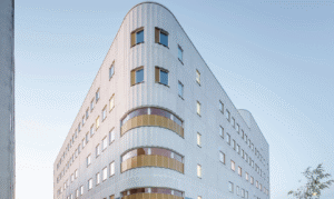 Vit fasad på Västerviks nya psykiatrisjukhus. Mjukt rundad kortsida som ger ett intryck av en trekantig byggnad.