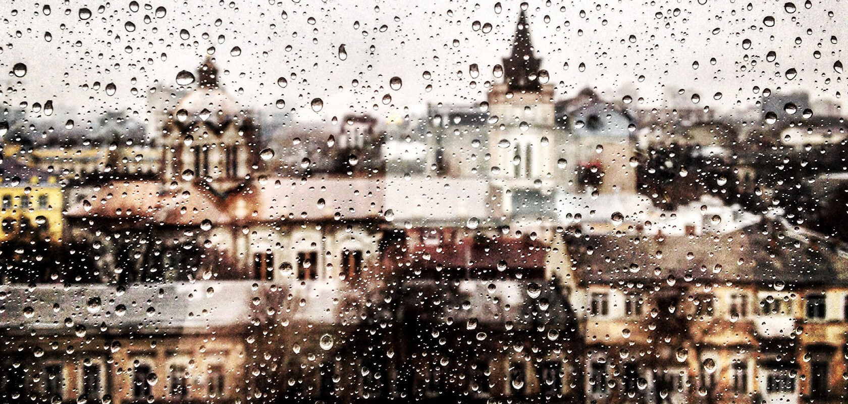 Regndroppar på fönster mot staden
