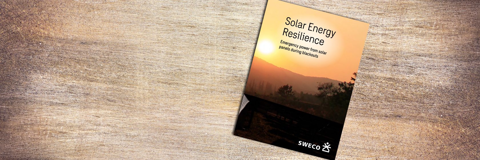 Broschyr liggande på bordskiva i trä