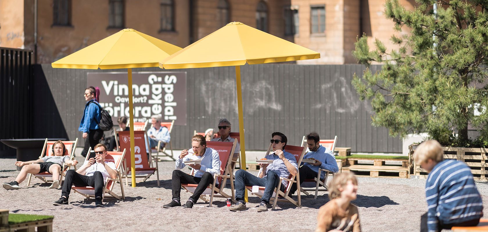 Människor i solstolar på ett torg
