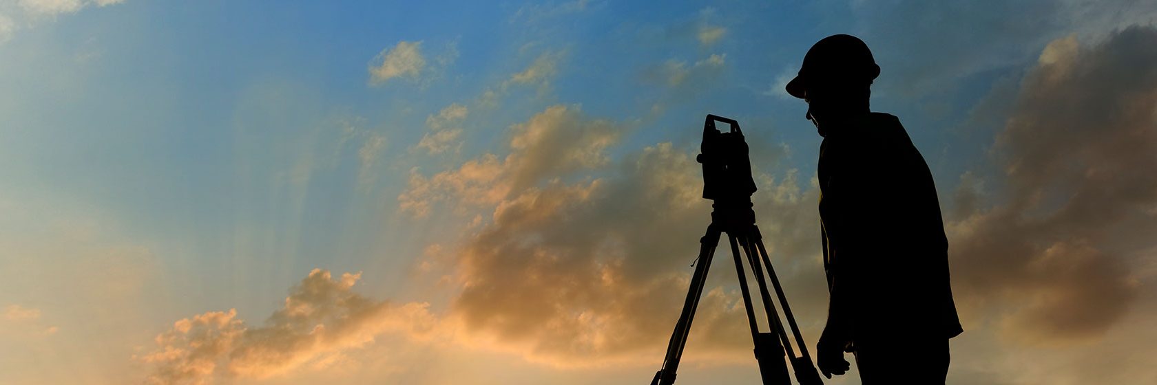 En lantmätare i profil under blå himmel