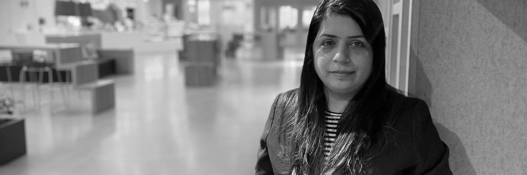 Svartvit bild på kvinna i stor lokal