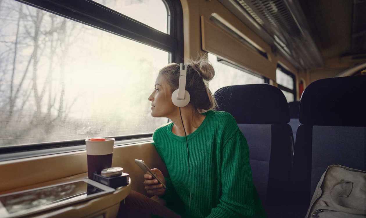 Kvinna tittar ut genom tågfönster