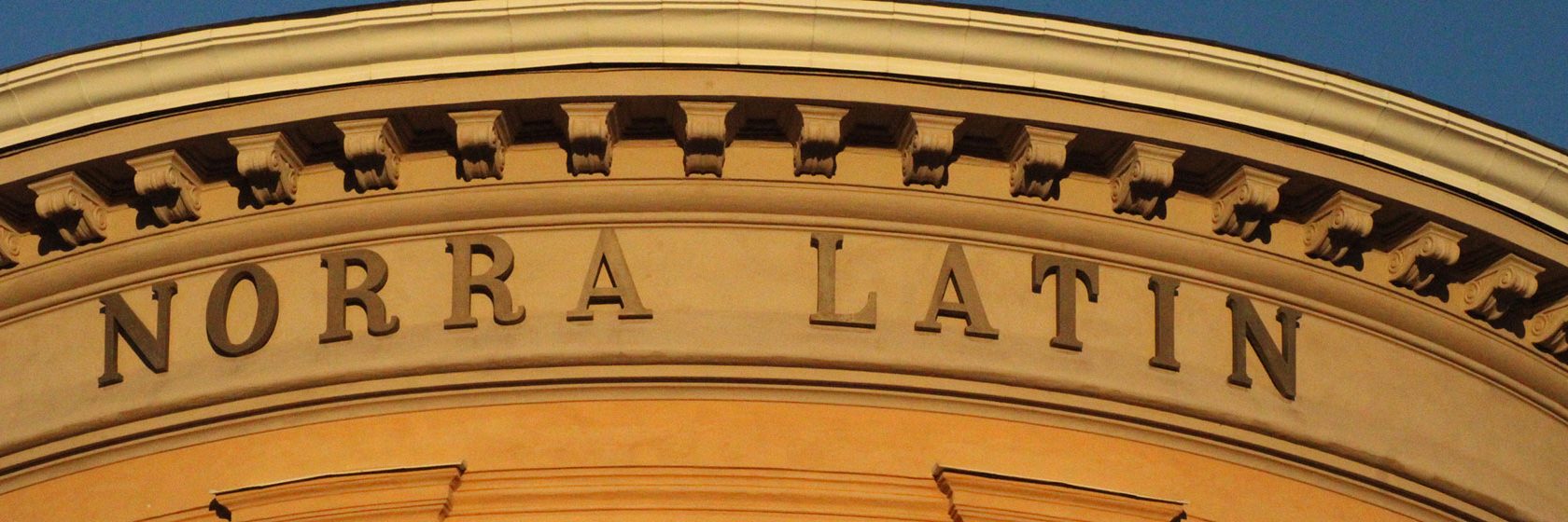 Närbild på Norra Latins gula fasad med namnet i fokus