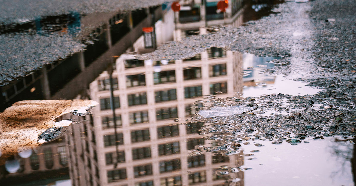 Spegling av hus i vattenpöl