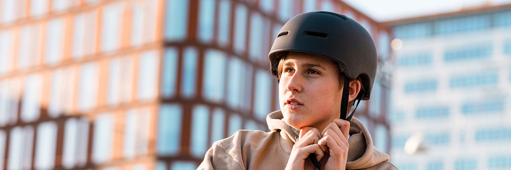 Kille spänner fast cykelhjälm