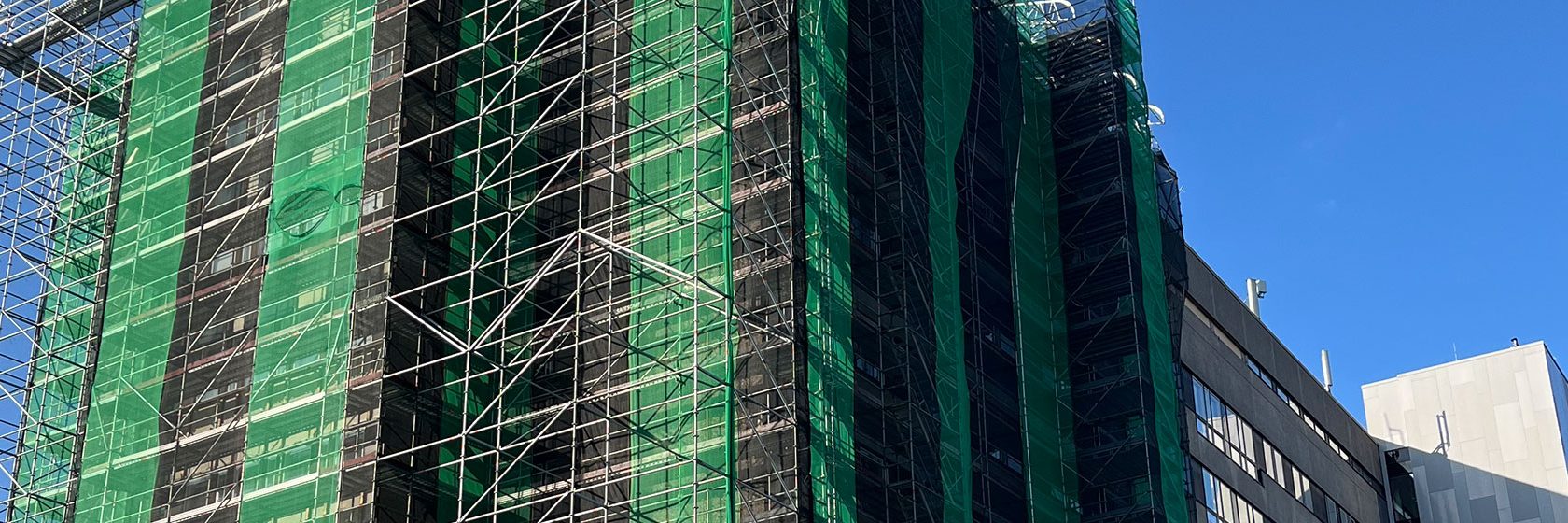 Centralkliniken vid östra Sjukhuset i Göteborg har en fasad inklädd med byggnadsställningar för fasadrenovering.