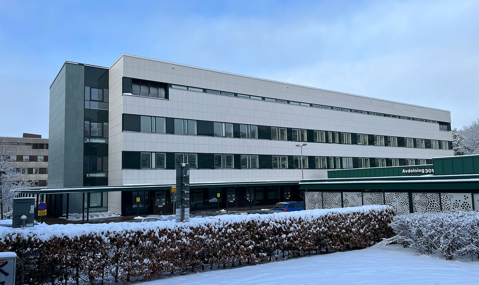 Infektionsklinikens fasad vid Östra sjukhuet i Göteborg. Vit, nyrenoverad fasad med blå himmel i ovankant.
