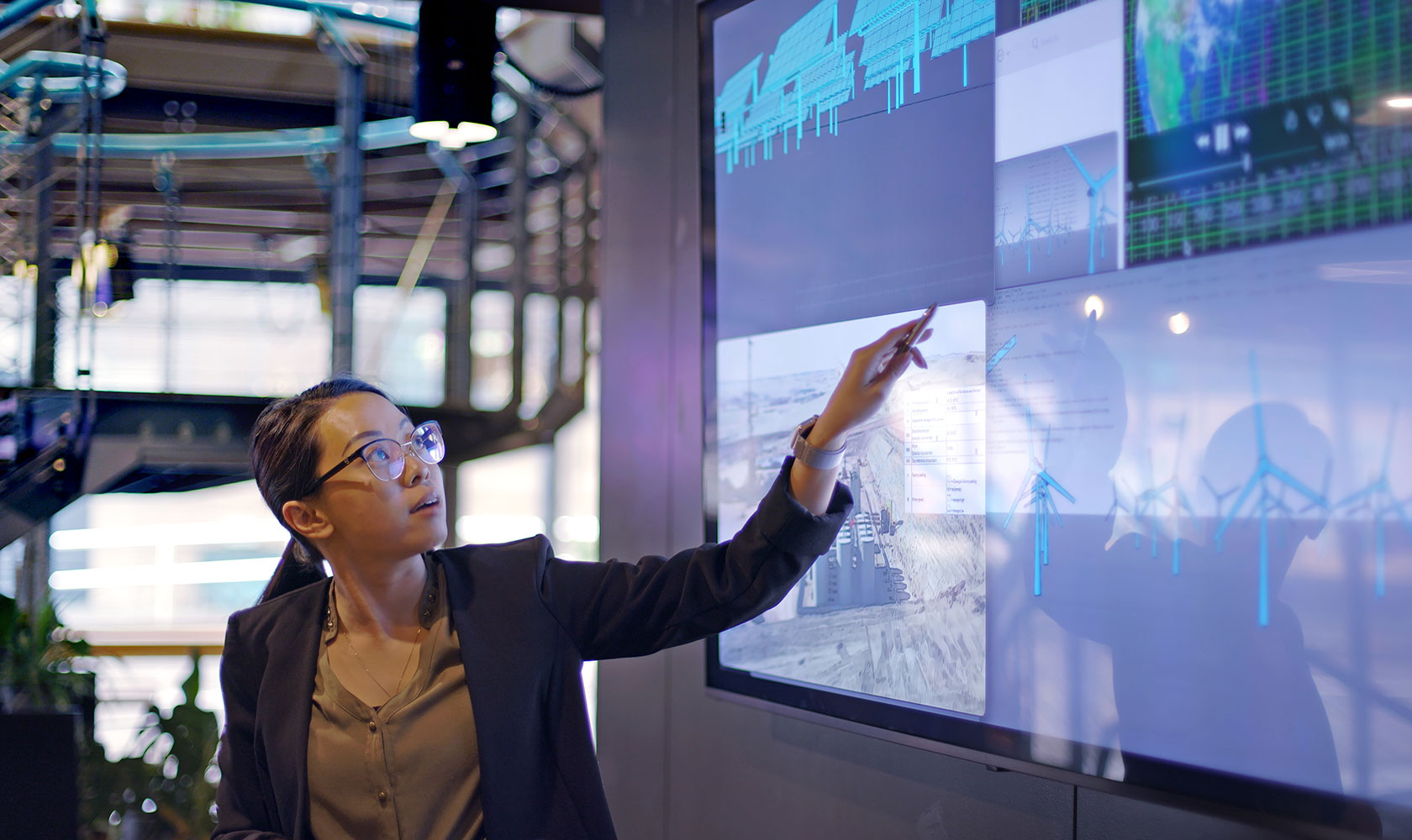 Kvinna pekar på skärm som visar vindkraftverk