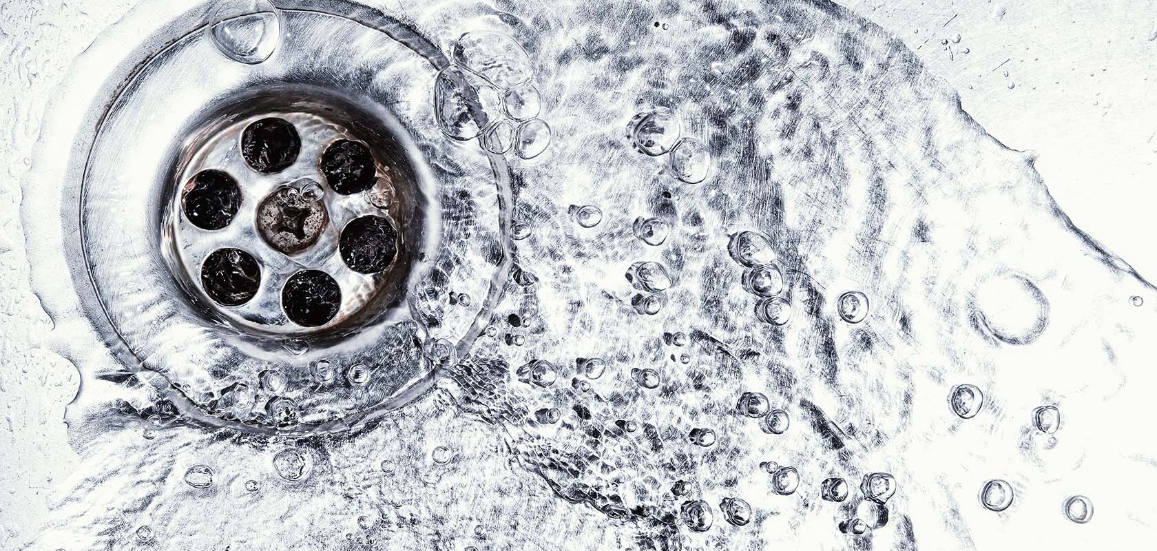 Vatten rinner ner i avlopp i diskho.