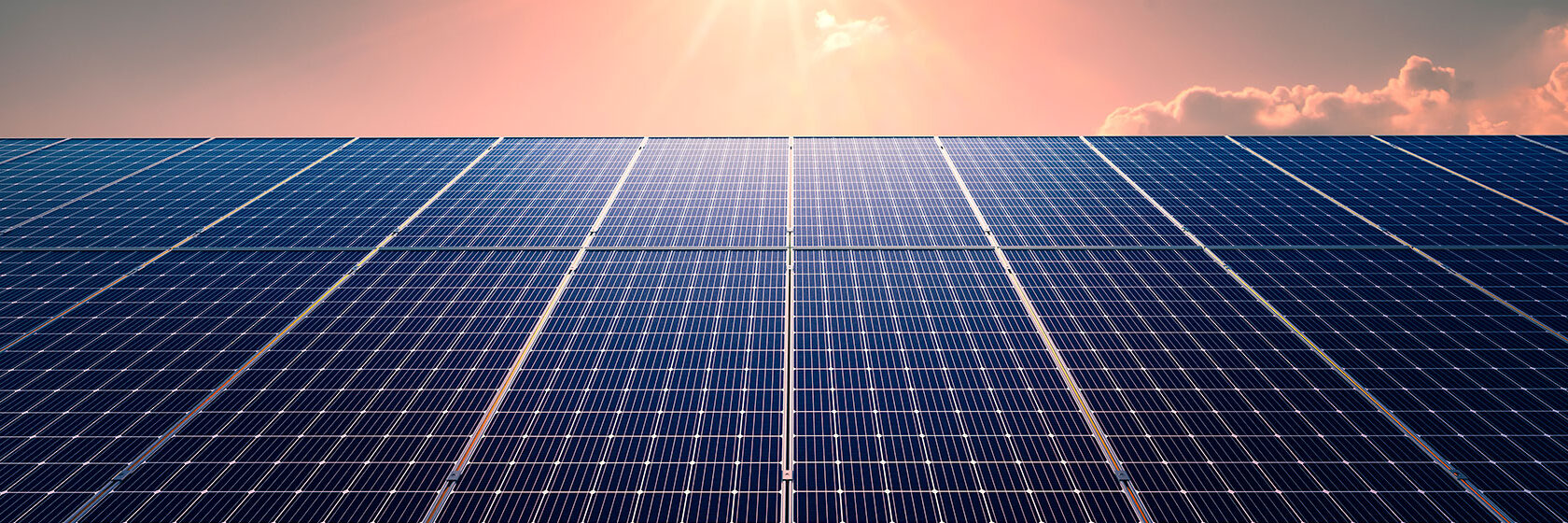 Närbild på solpaneler med stark sol i bakkant