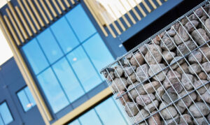 Glasfönster med träfasad och en samling stenar i förgrunden