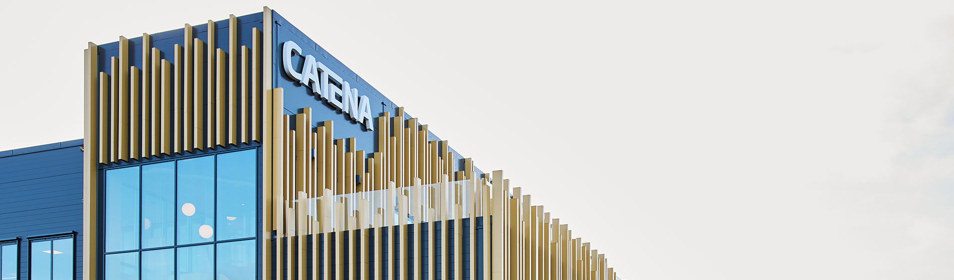 Träfasad med glasfönster och Catenas logotyp