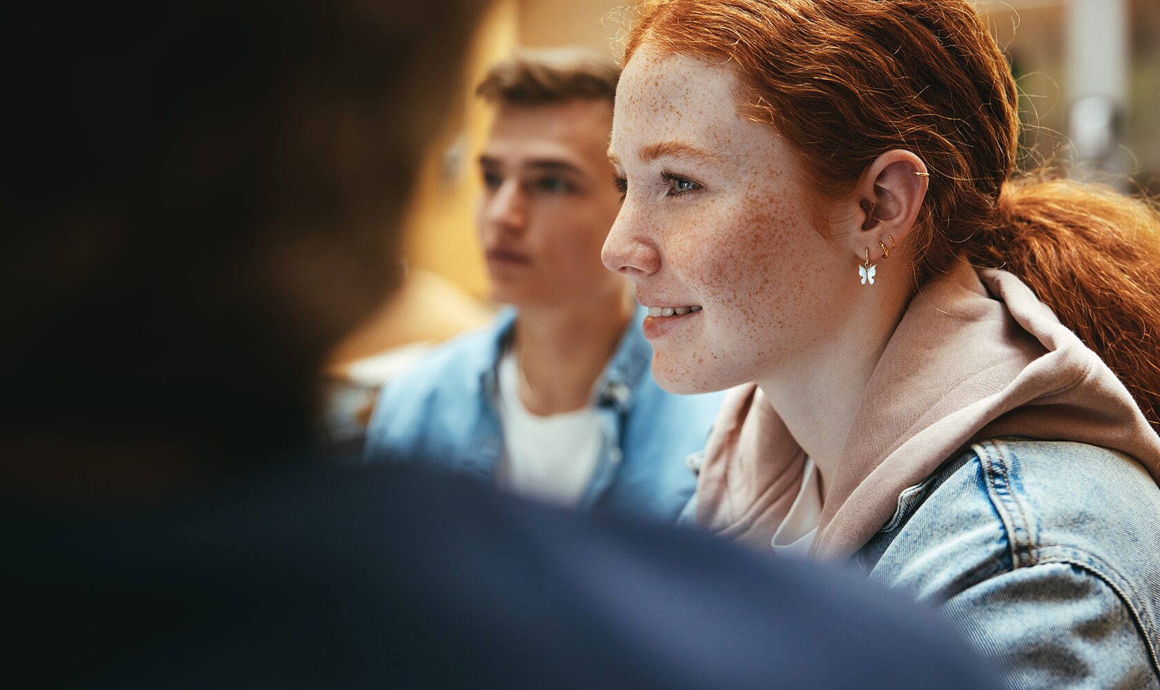 Rödhårig ung kvinna som deltar i en gruppdiskussion i närbild