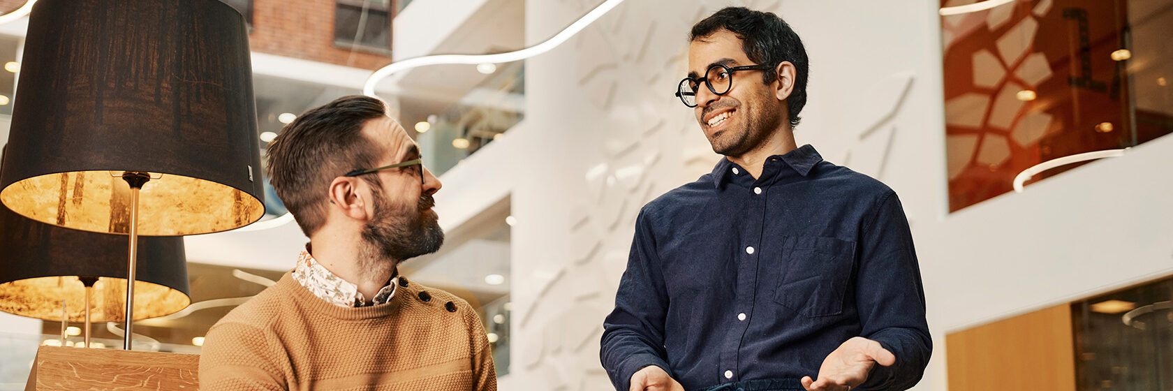 Två män samtalar över en dator