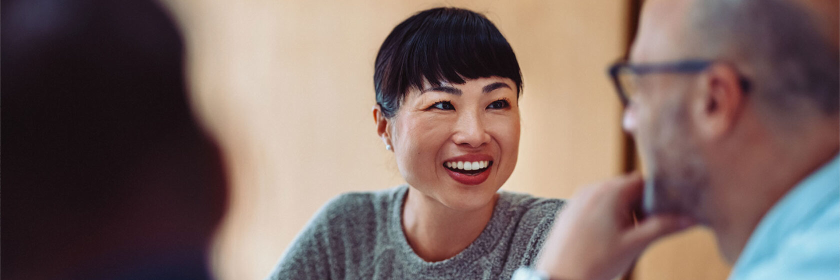 Människor som diskuterar vid ett bord i ett mötesrum.