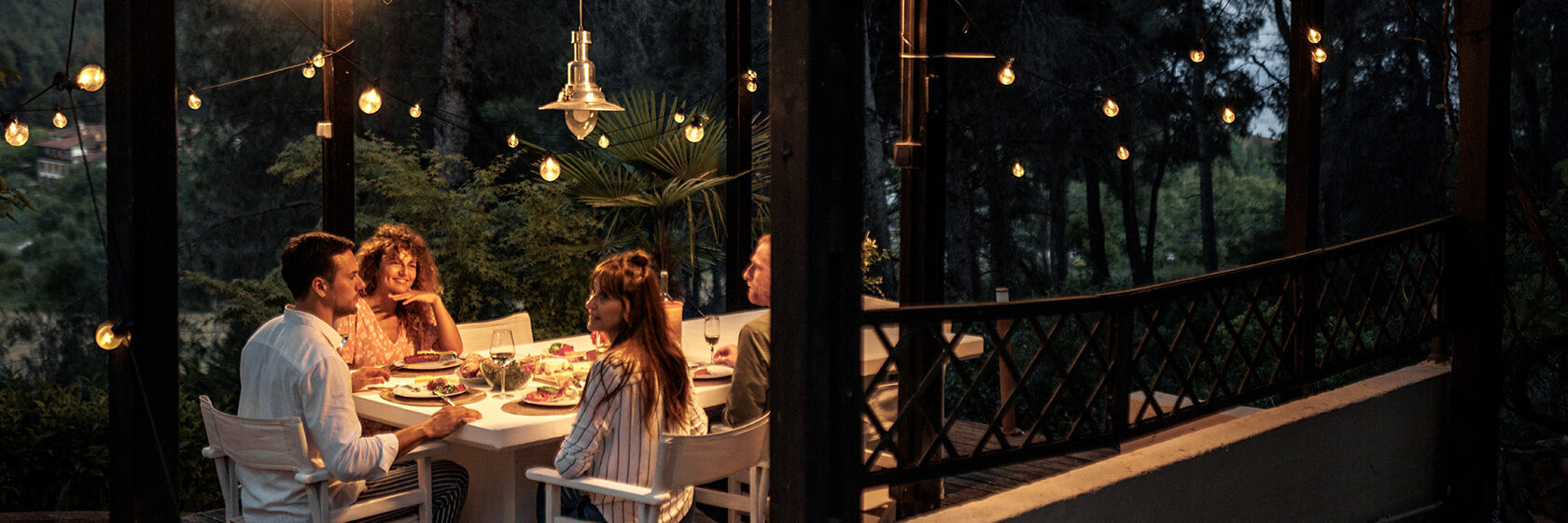 Människor sitter utomhus under belysning