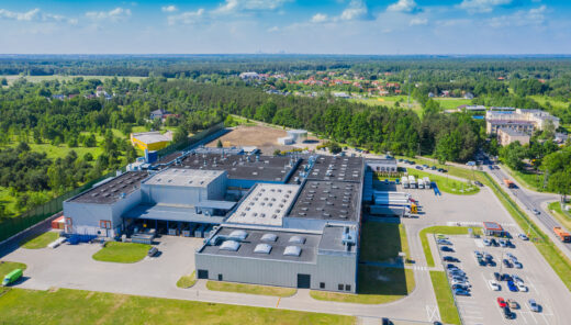 Fabrik med skog och parkering runtom