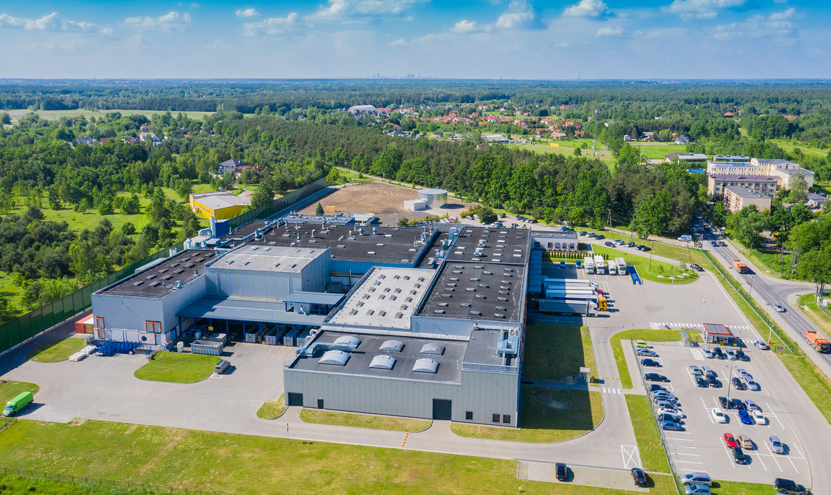 Fabrik med skog och parkering runtom