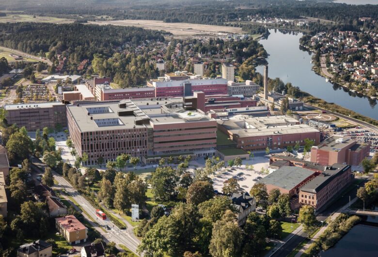 Flygfoto av Centralsjukhuset i Karlstad, omgiven av grönska och vatten.