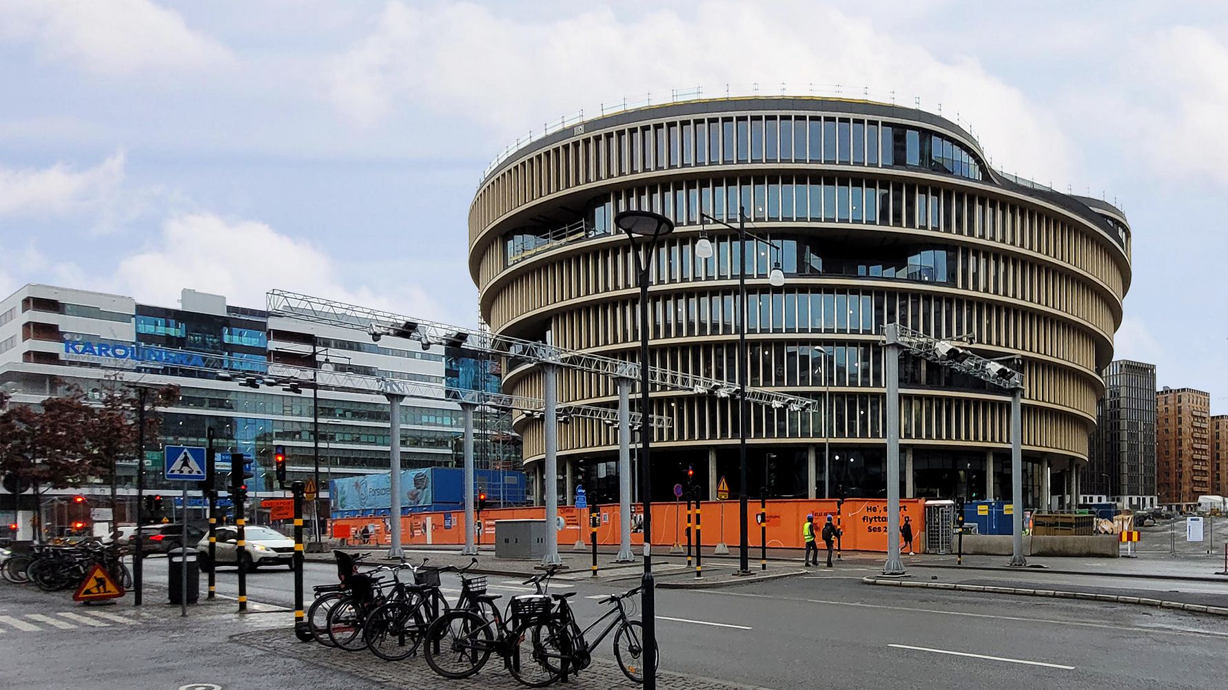 Modern byggnad i Solna, Sverige med cyklar, gångväg och Karolinska Institutet i bakgrunden