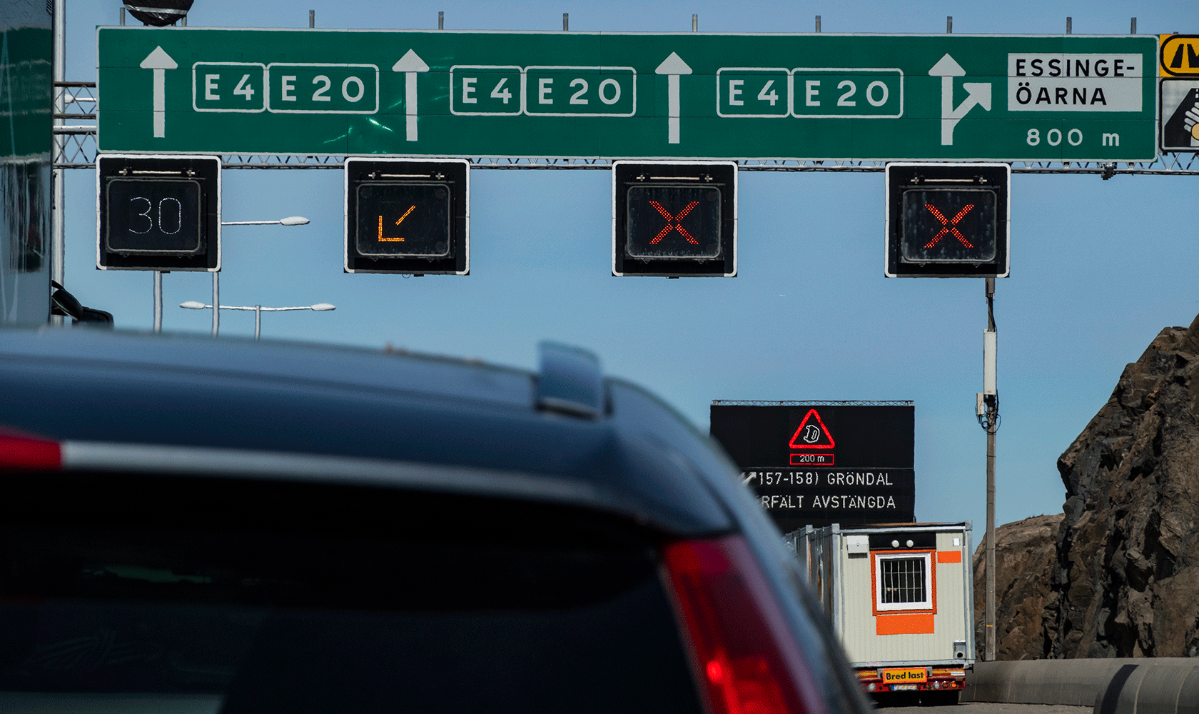 Vägskylt ovan motorväg med gröna skyltar som visar mot E4 och E20