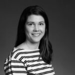 Svartvit porträttbild av kvinna i långt mörkt hår och randig tröja