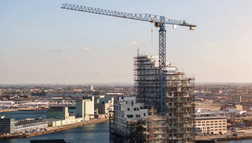 Översiktsbild av Malmö hamn med lyftkran och pågående bygge av större fastighet