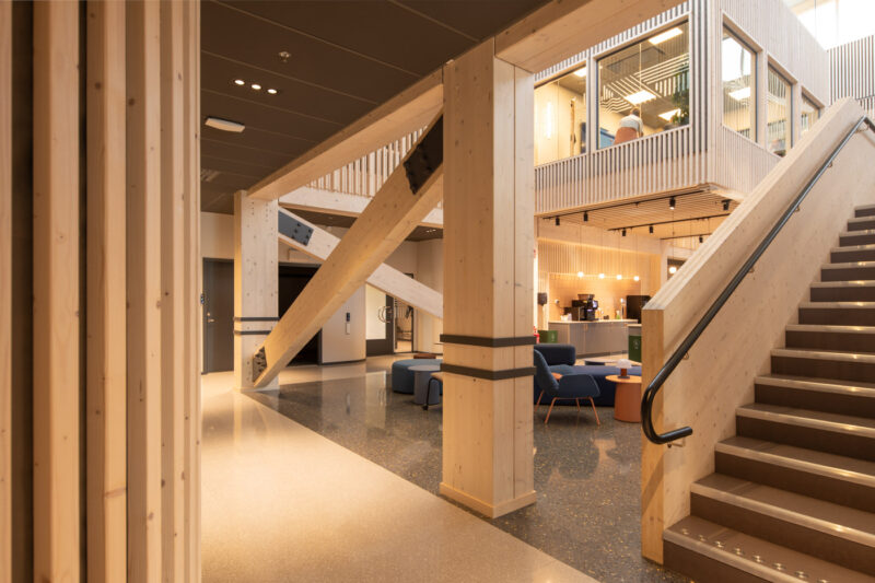 Interiör med trappa och pelare i modernt kontor.