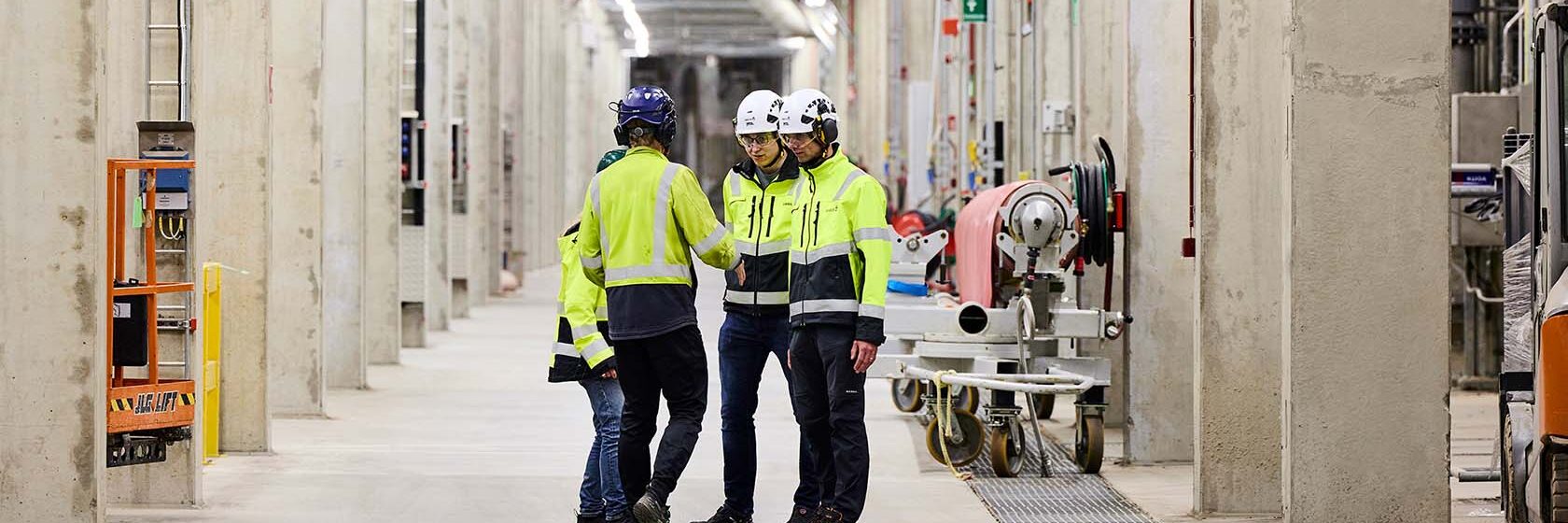 Människor i byggkläder på ett lager