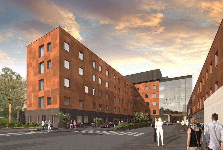 Visualisering av modernt sjukhus med glasentré och tegelröda byggnader i kvällsljus