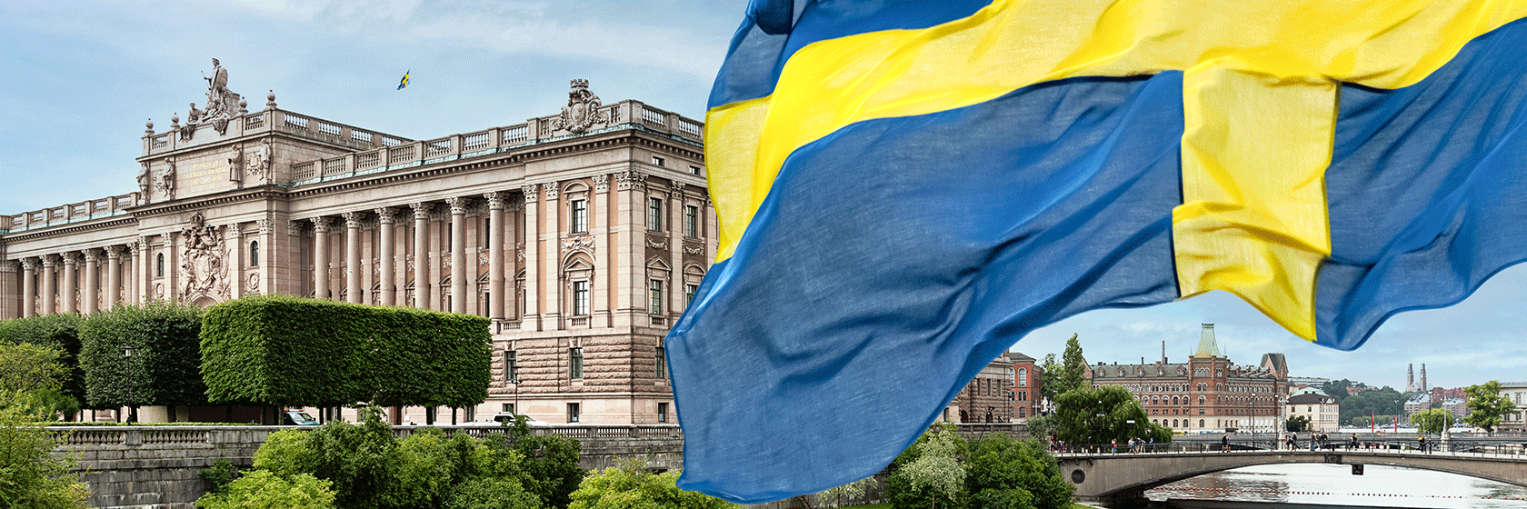 Riksdagshuset och Riksbanksbron över Lilla Värtan-sundet, med Sveriges nationalflagga i förgrunden.