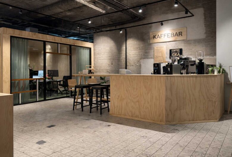 Modern kaffebar i kontorslobby med träbar, espressomaskin och sittplatser